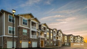 Modern three-story apartment building with stone and beige siding, white trim, balconies, and well-lit exterior at sunset. A sign reads “Ascent 430, Wexford, PA” in the lower right corner.