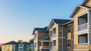 Modern apartment buildings with light yellow siding, white trim, and stone accents under a clear blue sky at sunset. Text in the corner reads: Ascent 430, Wexford, PA.