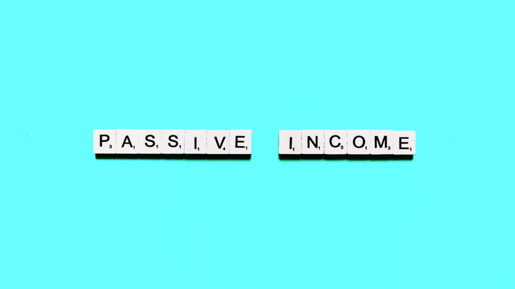 White letter tiles spell PASSIVE INCOME on a bright blue background, with the two words separated by a small gap.