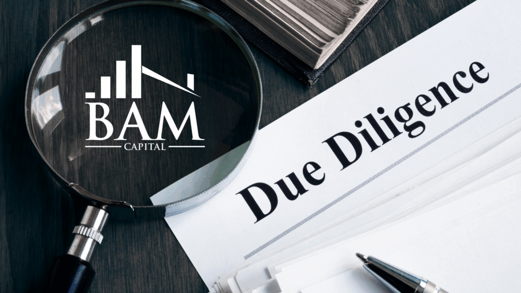 A magnifying glass with the BAM Capital logo hovers over a document titled Due Diligence, with a stack of papers and a book in the background.