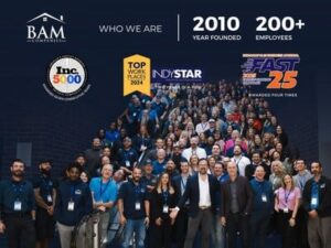 A large group of BAM Companies employees pose together, smiling, under banners showing awards and stats: founded in 2010, over 200 employees, and multiple workplace awards including Inc. 5000, Top Workplaces 2024, and Fast 25.