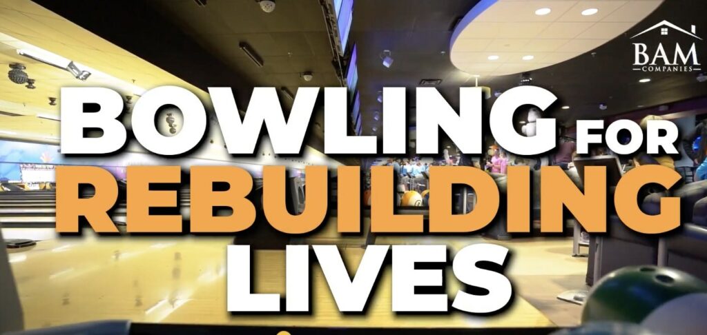 A bowling alley with the words BOWLING FOR REBUILDING LIVES in large, bold letters across the image. The BAM Companies logo is in the upper right corner.