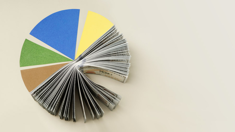 A pie chart with colorful segments, with one segment replaced by a fanned-out stack of U.S. dollar bills, illustrating the concept of financial distribution or budget allocation.