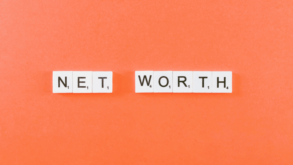Scrabble letter tiles on an orange background spell out NET WORTH.