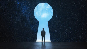 A person in a suit stands in front of a giant keyhole-shaped portal, surrounded by a star-filled night sky, gazing into a bright, cloudy light beyond the opening.