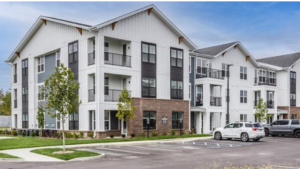A BAM Capital slide featuring the title accredited investor vs. qualified purchaser, with a photo of a modern multifamily apartment community in Whitestown, Indiana.