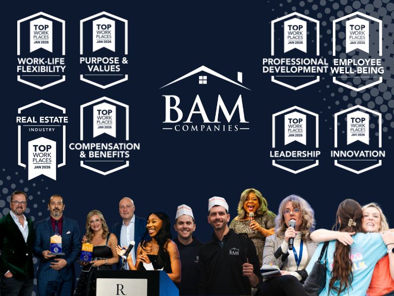Group photo of BAM Companies event against a dark backdrop featuring Top Work Places badges and the BAM logo, with staff posing in front of a stage.